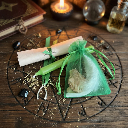 Abundance spell kit with candle and scroll on rustic occult carved wooden surface