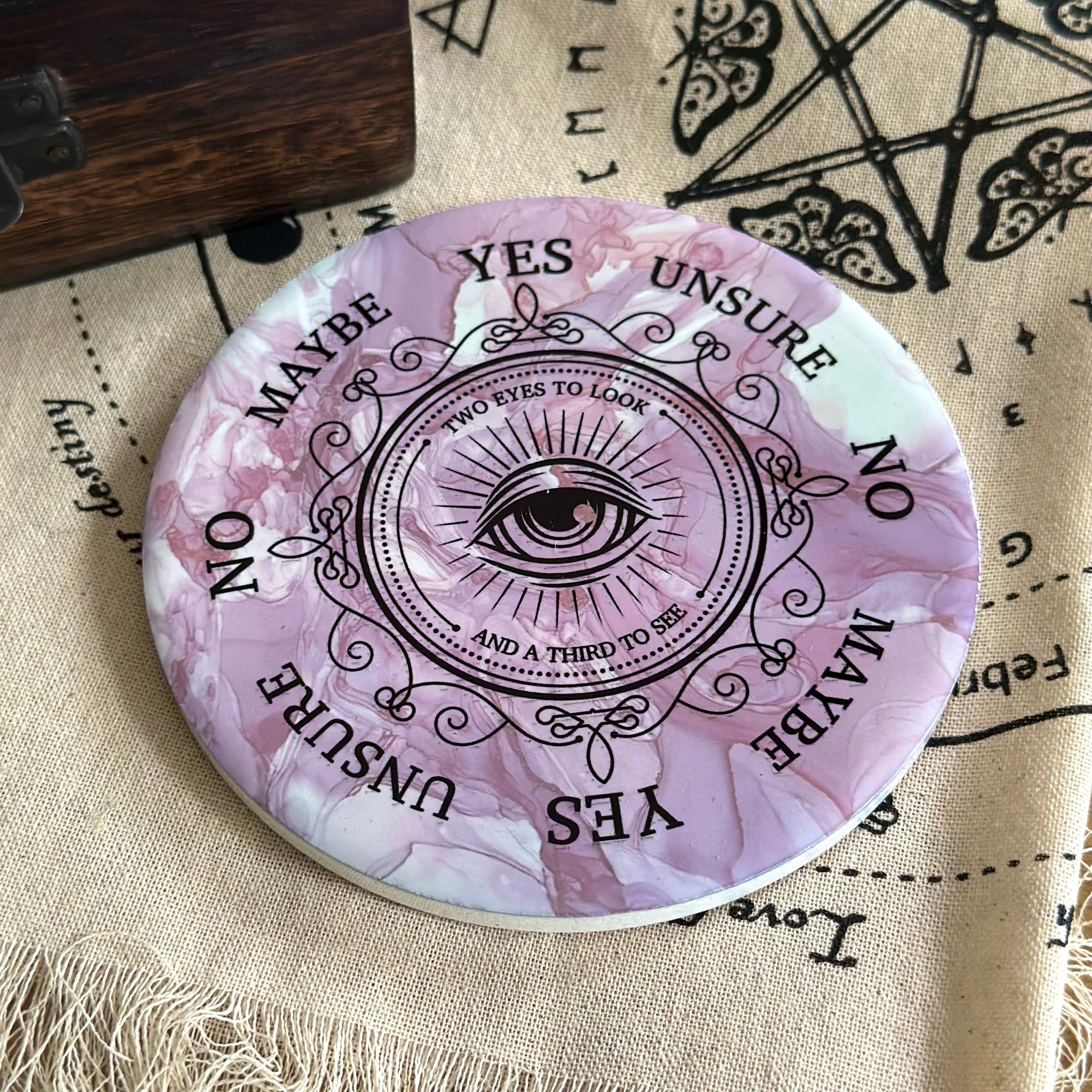 All seeing eye pendulum board on a cream cloth background