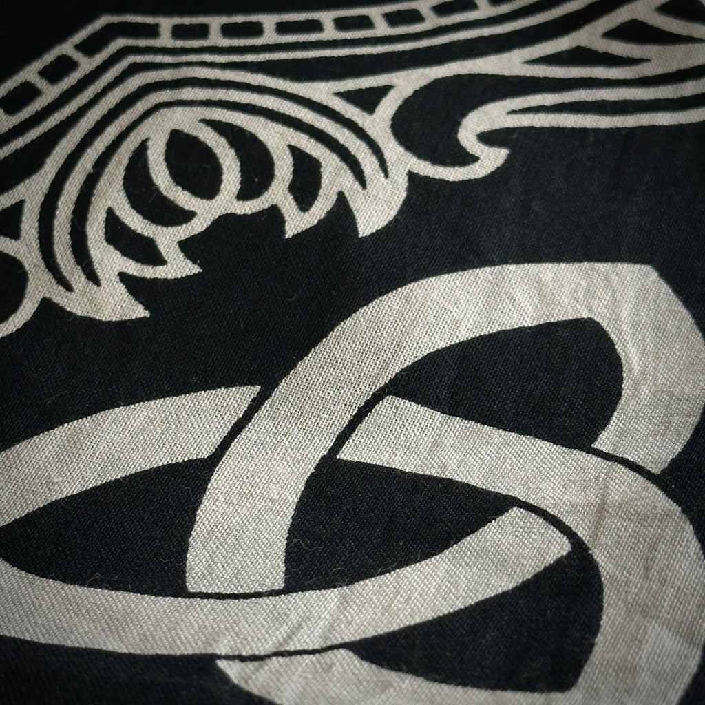 Close up of part of the altar cloth design, ivory symbols on a black background. 