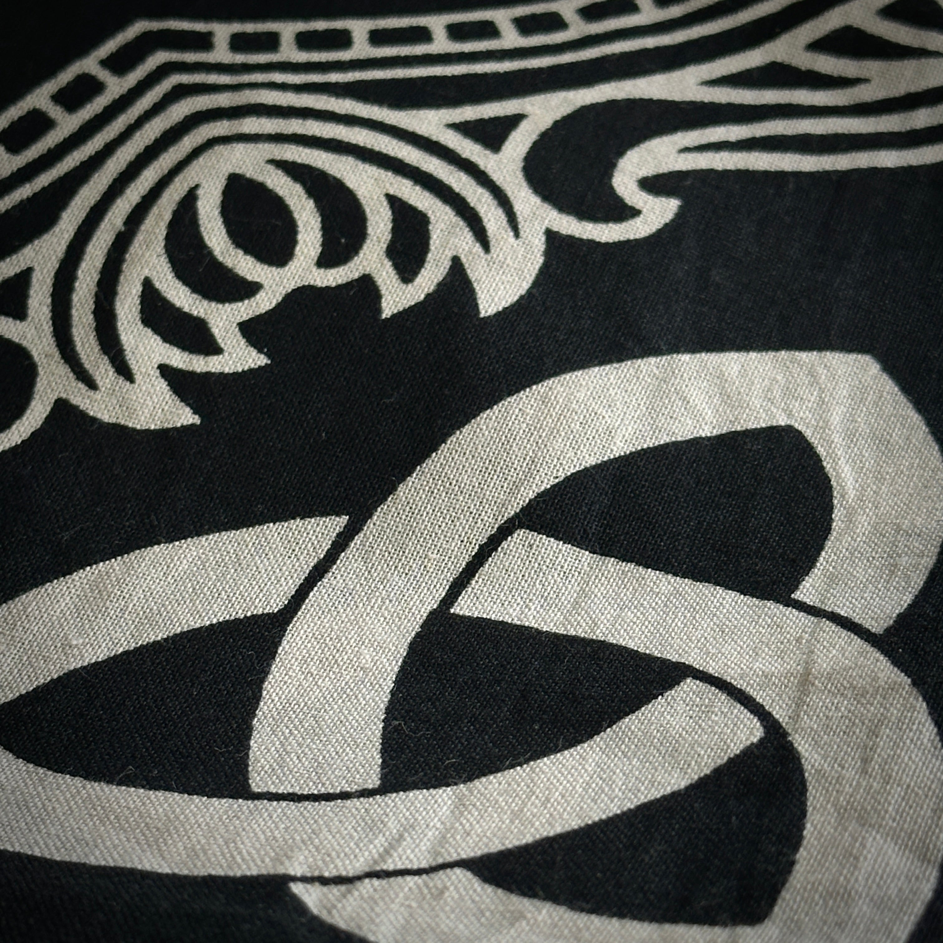 Close up of part of the altar cloth design, ivory symbols on a black background. 