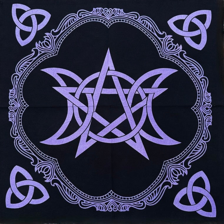 Black altar cloth with purple pentagram and triple moon design on a wooden surface