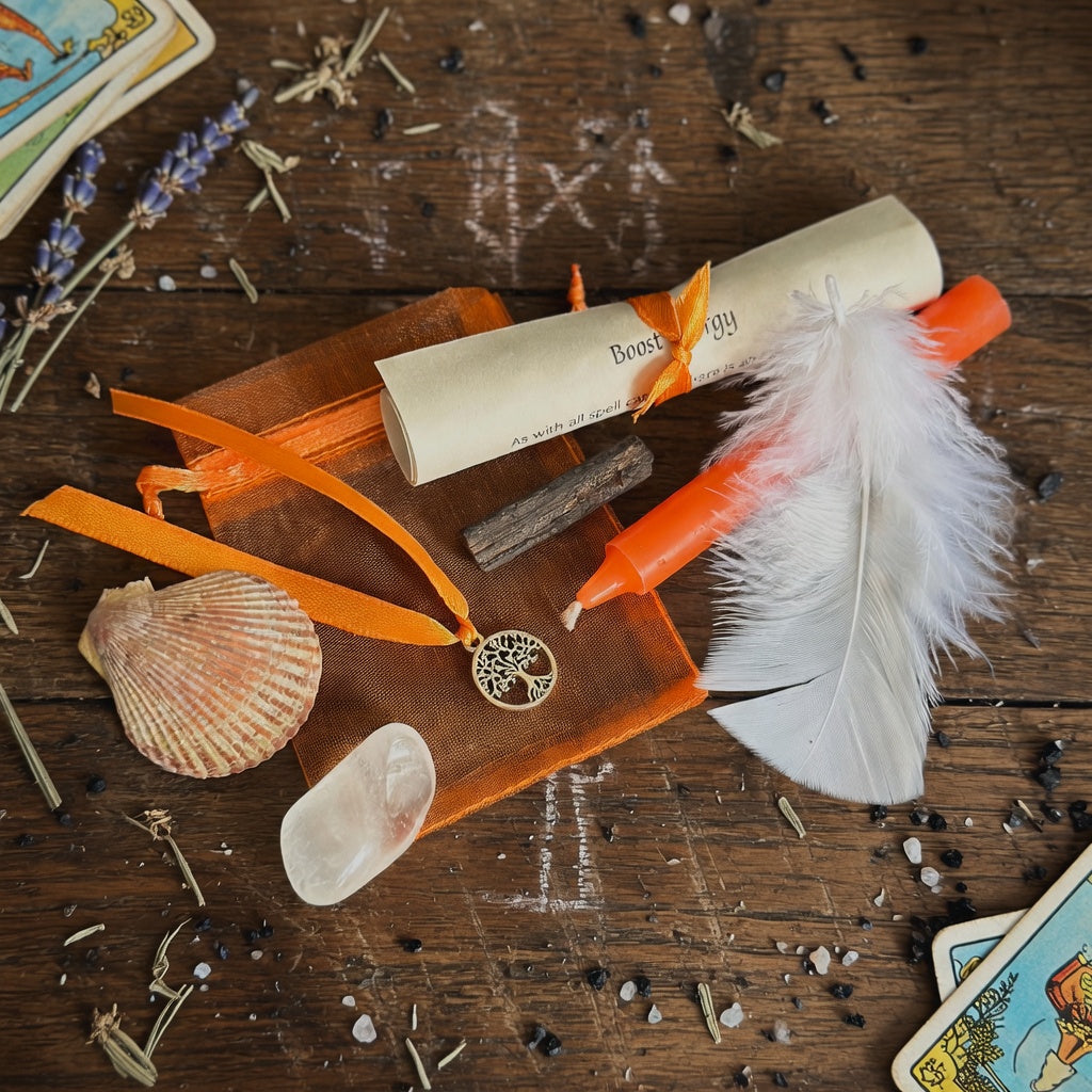 Boost energy spell kit with scroll, feather and candle on wooden surface. Witchcraft and sorcery items