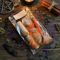 Moonlit Shadow boost energy spell kit, on a wooden surface with a sprinkle of herbs and witchcraft related items