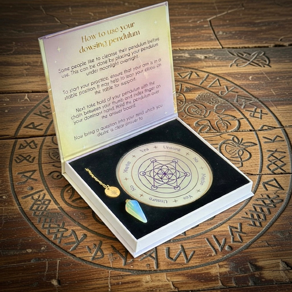 Dowsing pendulum set with instructions on a wooden surface with runes.