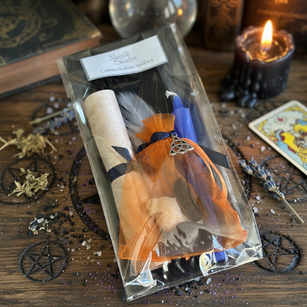 Communication spell kit in its packaging, lying on a wooden surface carved with witchcraft symbols, with a candle and book