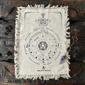 Mystic moth design natural cotton pendulum divination cloth, on a wooden surface, featuring the brand 'Ancient Witch'.