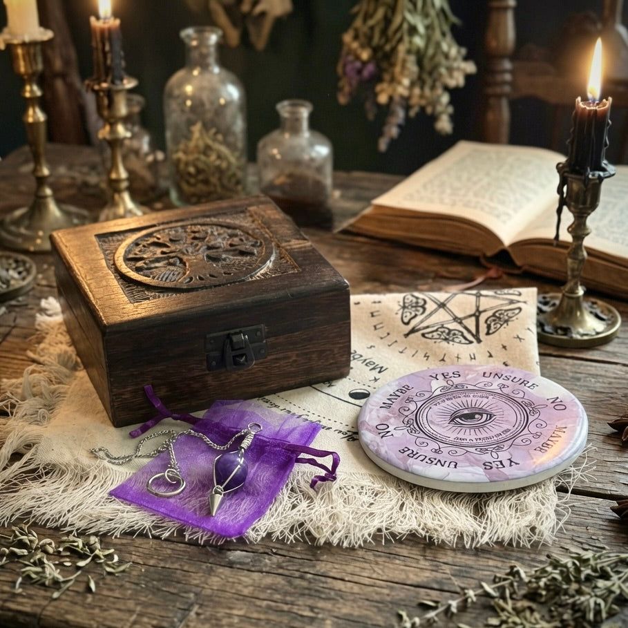 Pendulum divination gift set with cloth, pendulum board, carved wooden box and amethyst pendulum on a rustic wooden table with candles