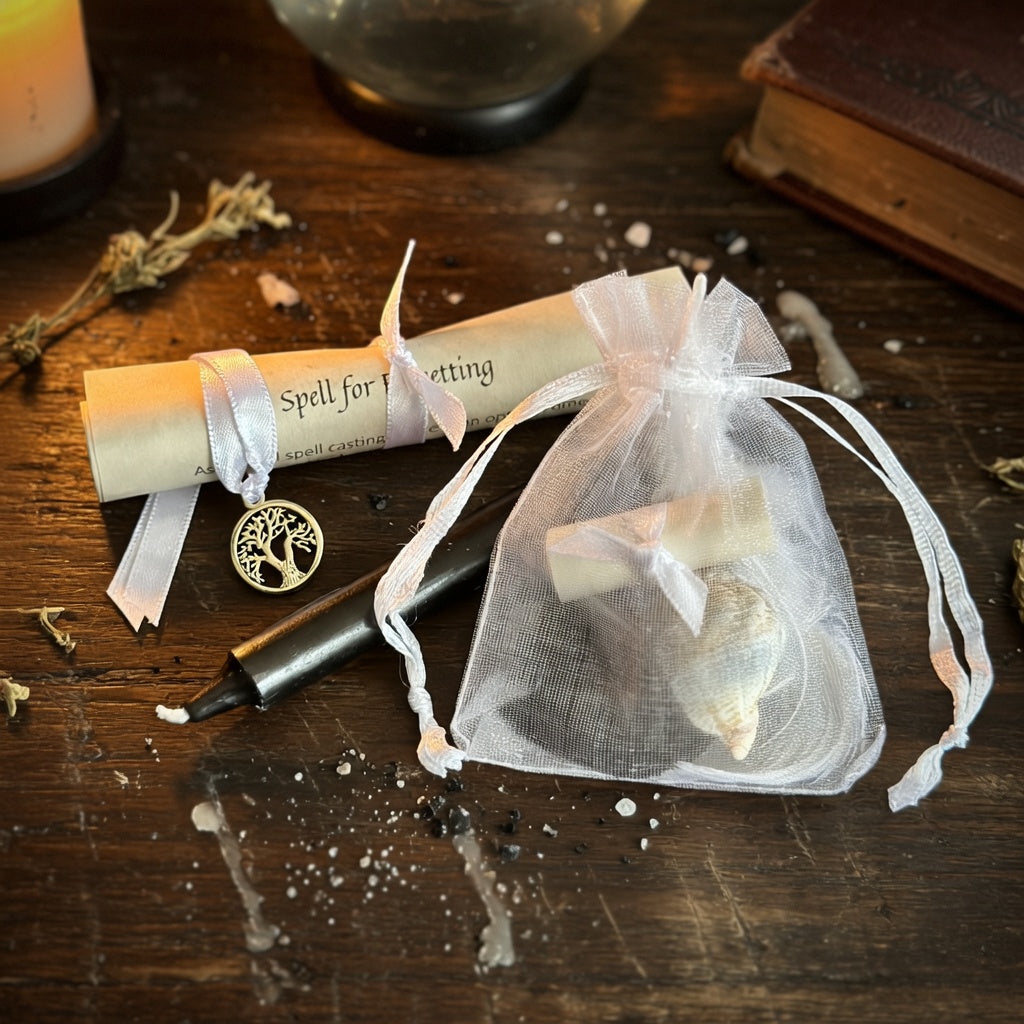 Letting go and forgetting spell kit with scroll and candle on a wood surface