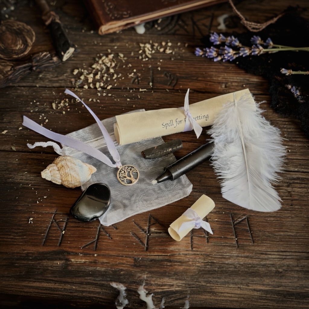 Letting go and forgetting spell kit with scroll, candle, feather and shell on an occult theme carved wooden surface
