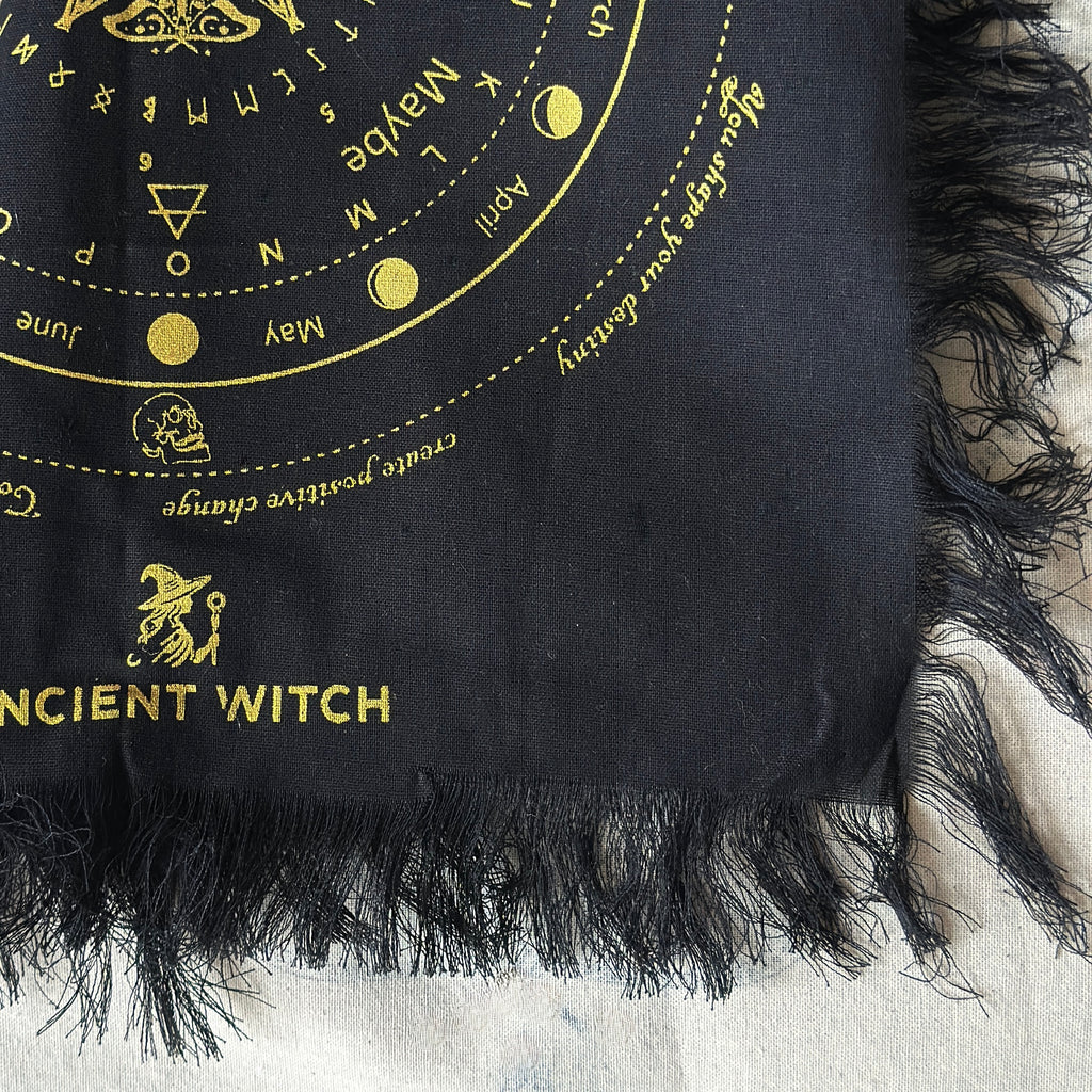 Black divination cloth with gold detailling on a textured surface