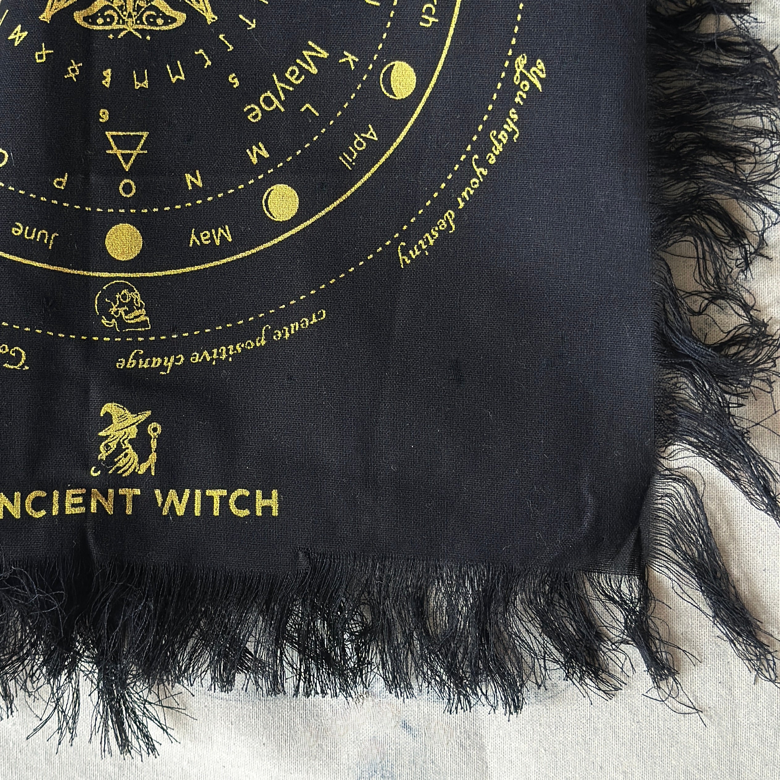 Black divination cloth with gold detailling on a textured surface