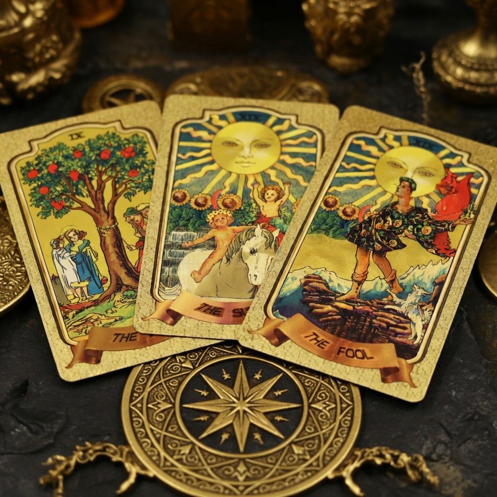 Three tarot cards with decorative gold border on a dark surface