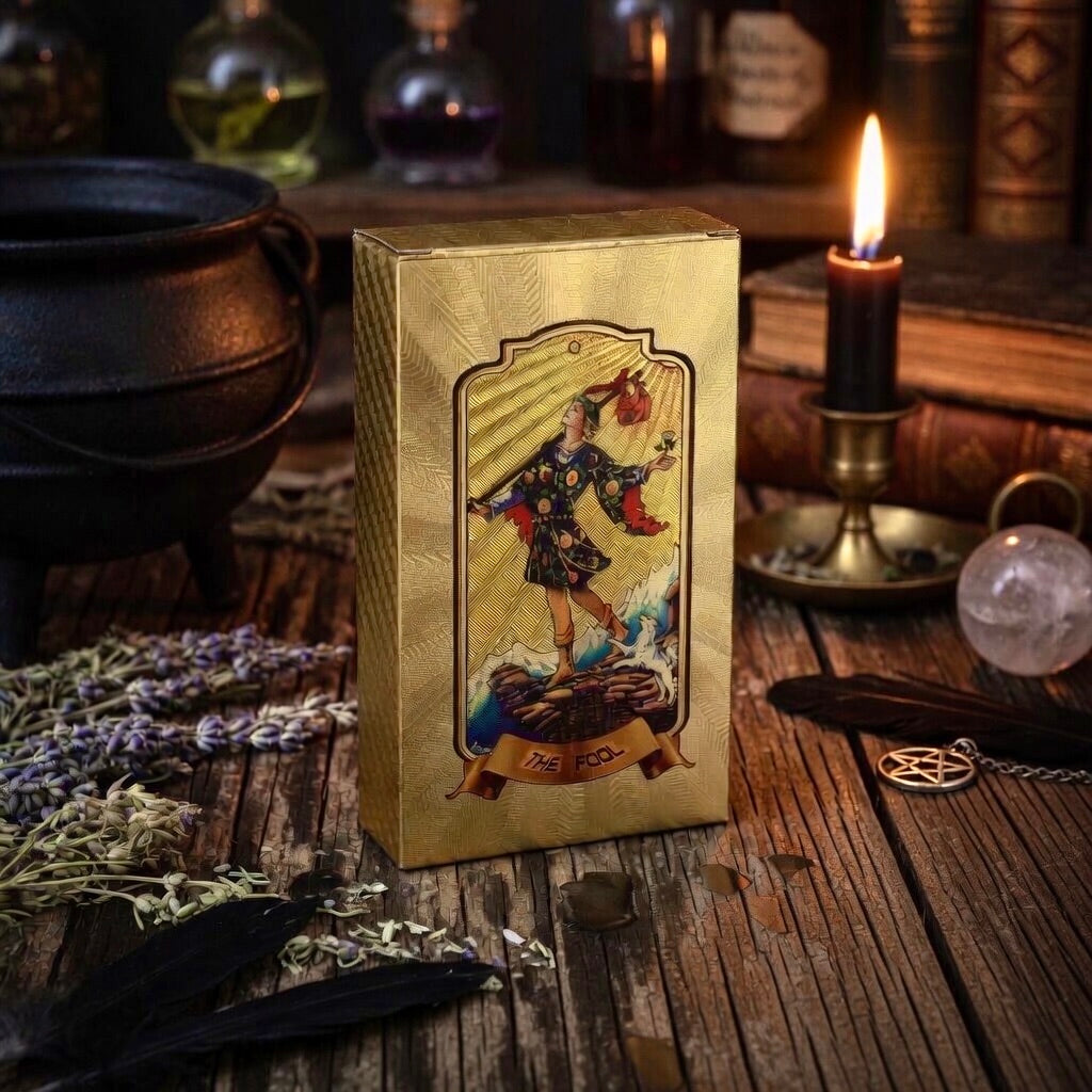 Gold tarot card box, on a mystical table with candles and herbs