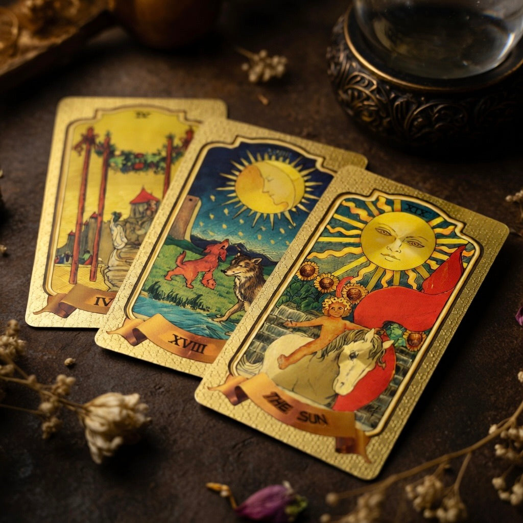 Three golden tarot cards on a dark surface with decorative elements