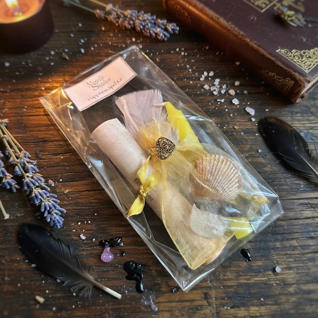Moonlit Shadow happiness spell kit on a wooden surface with sprinkling of herbs and a book