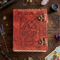 Red / brown leather-bound book titled 'Dream Book' on a wooden surface with mystical items.