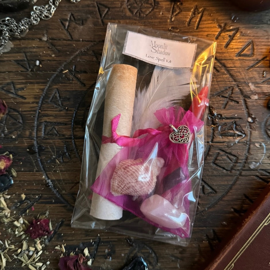 Moonlit Shadow love spell kit with scroll and candle on rough wooden surface with occult symbols
