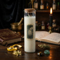 Magic spell candle in a glass jar with a label on a dark wooden surface with books and bottles in the background