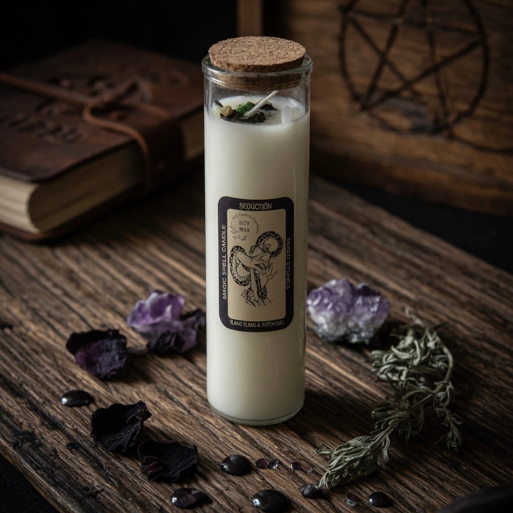 Magick spell candle for seduction in a glass jar with a cork lid on a wooden surface with purple flowers and a pentacle symbol.