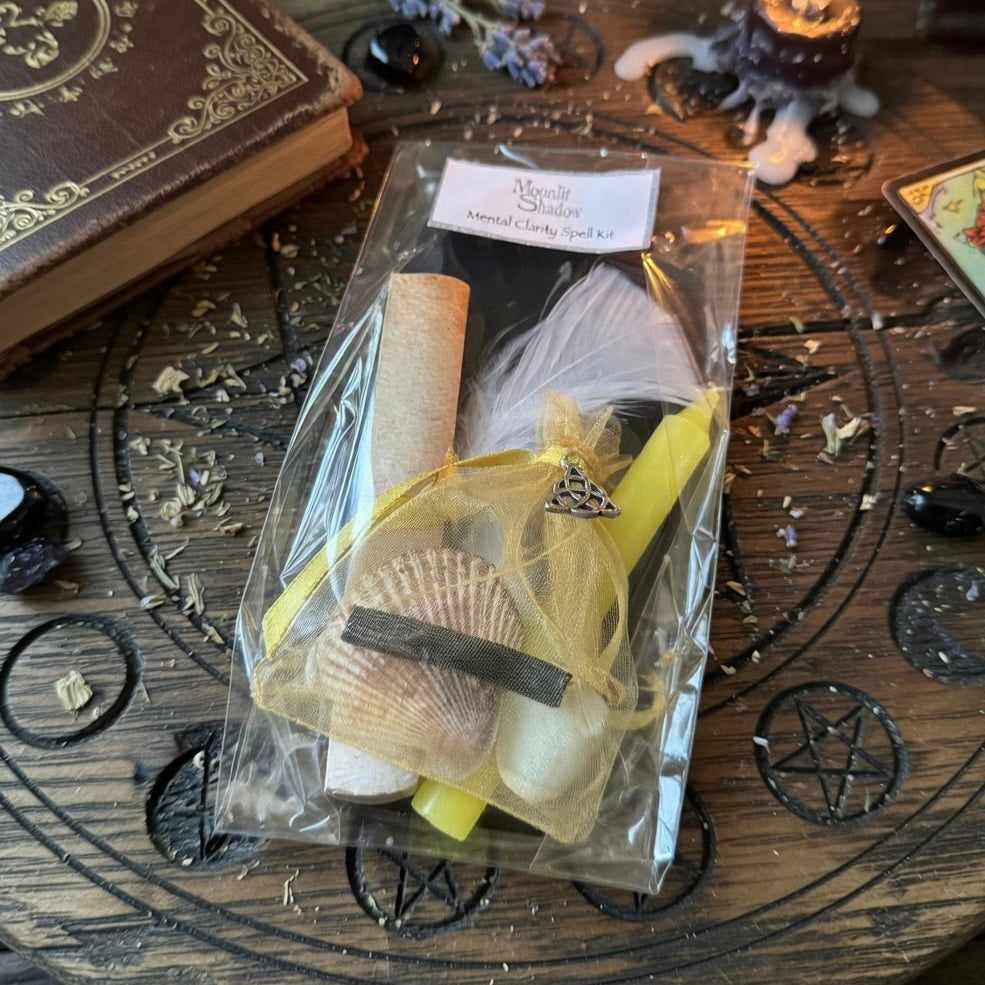 Moonlit Shadow mental clarity spell kit on a carved wooden surface with sprinkle of herbs and a book