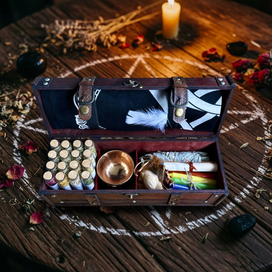 Open wooden witchcraft chest on a wooden surface with various items including bottles, a feather, and a candle.