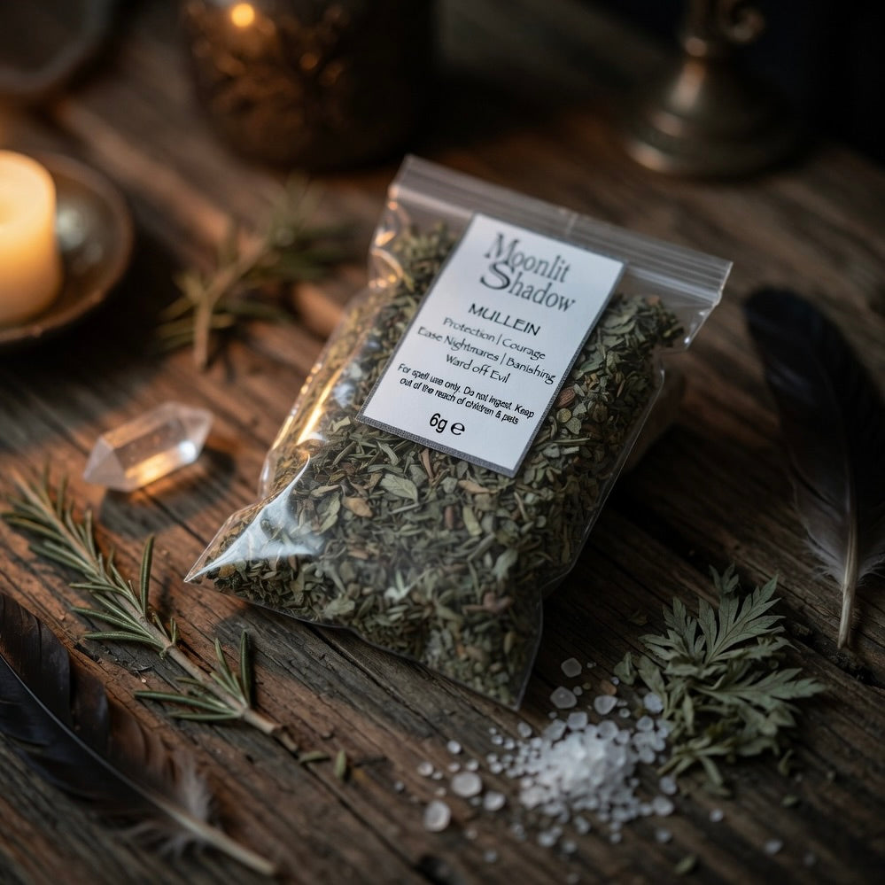 Packaged mullein spell herbs labeled 'Moonlit Shadow' on a wooden surface with candles and crystals.