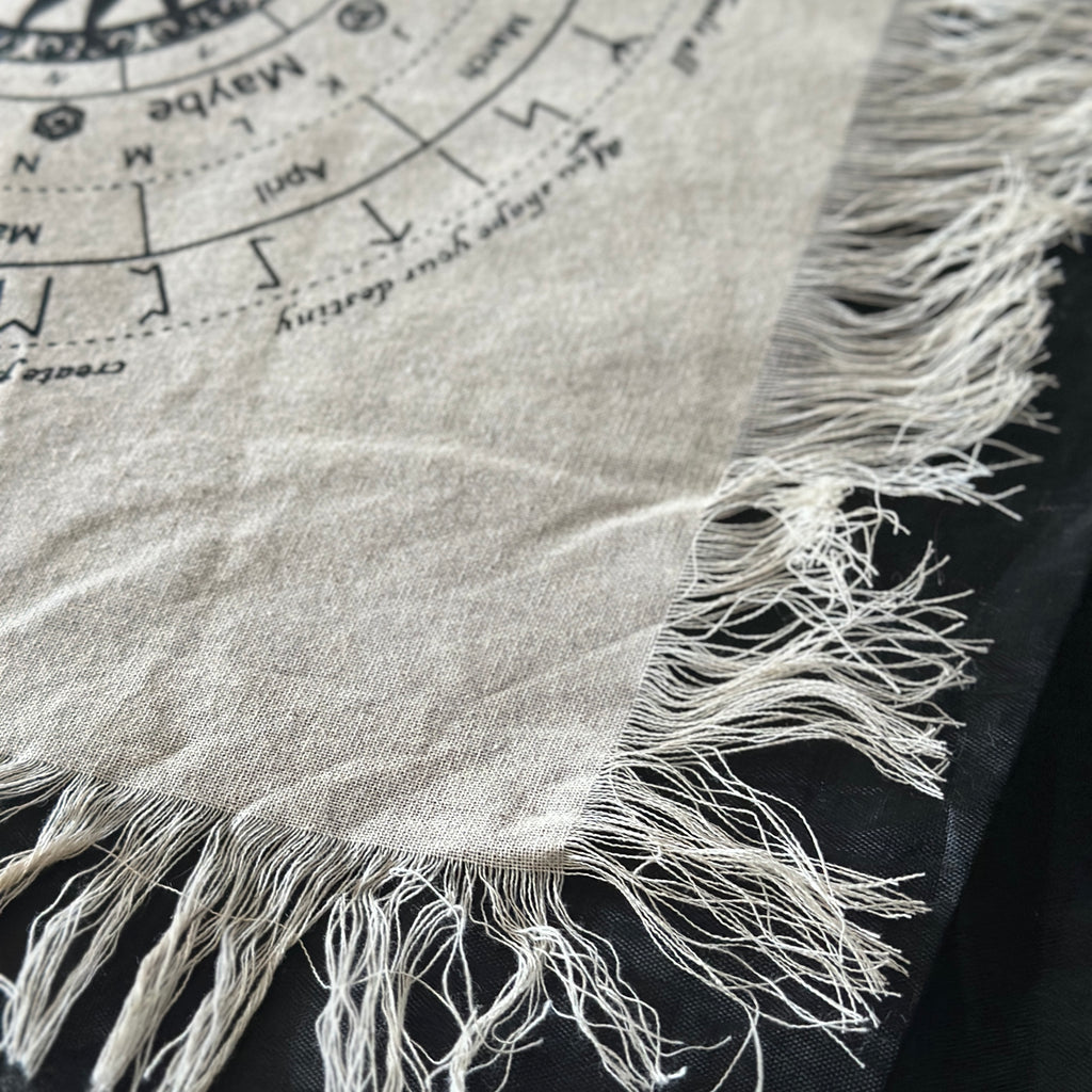 Pendulum divination cloth fringing on a black background