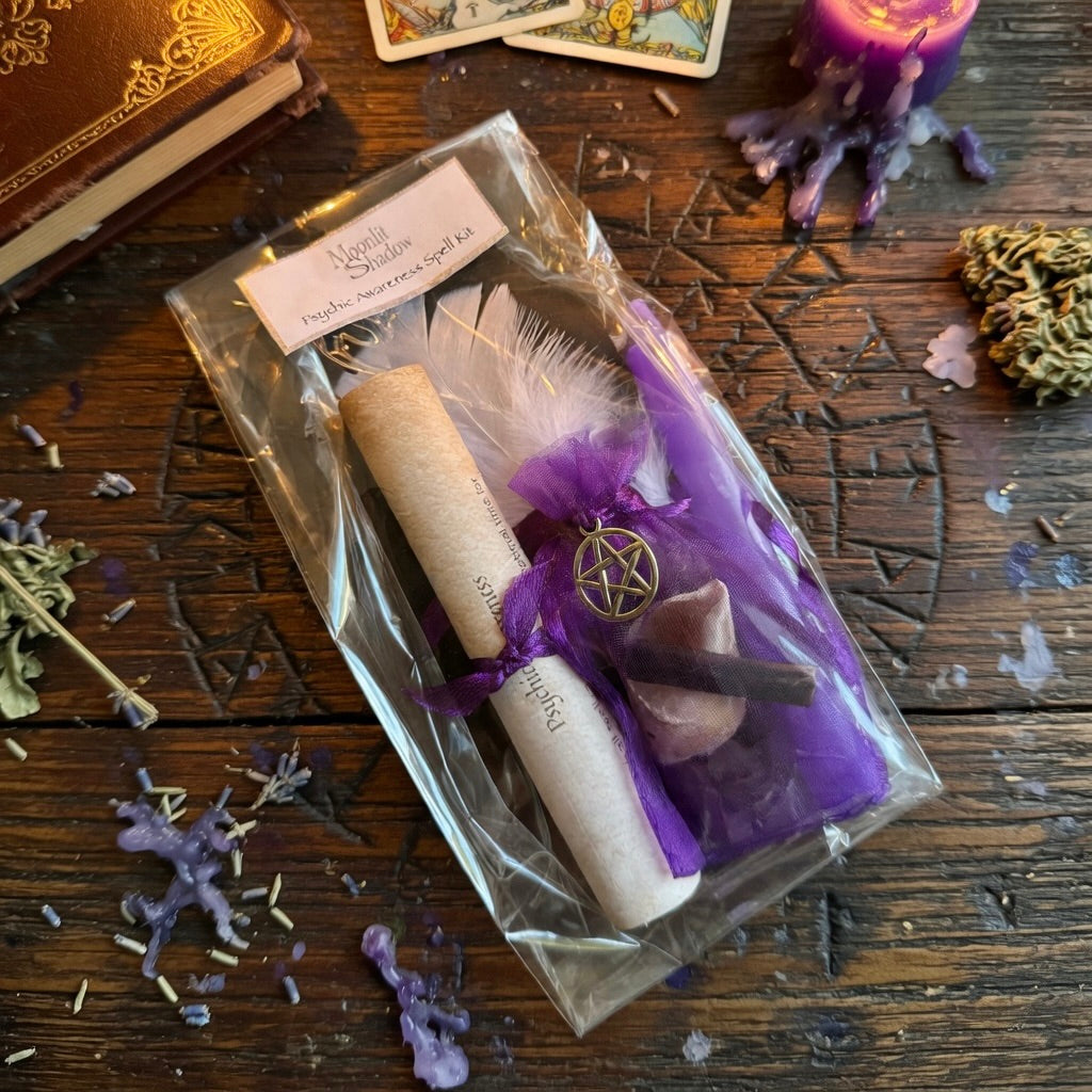 Moonlit Shadow psychic awareness spell kit on a wooden surface with occult carvings, a sprinkling of herbs and a book