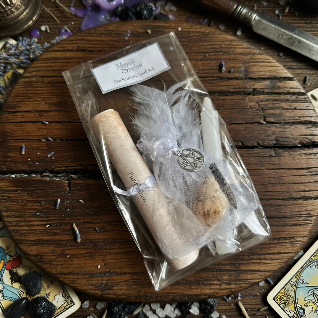 Purification spell kit with scroll and candle on a wood surface with an athame and tarot cards