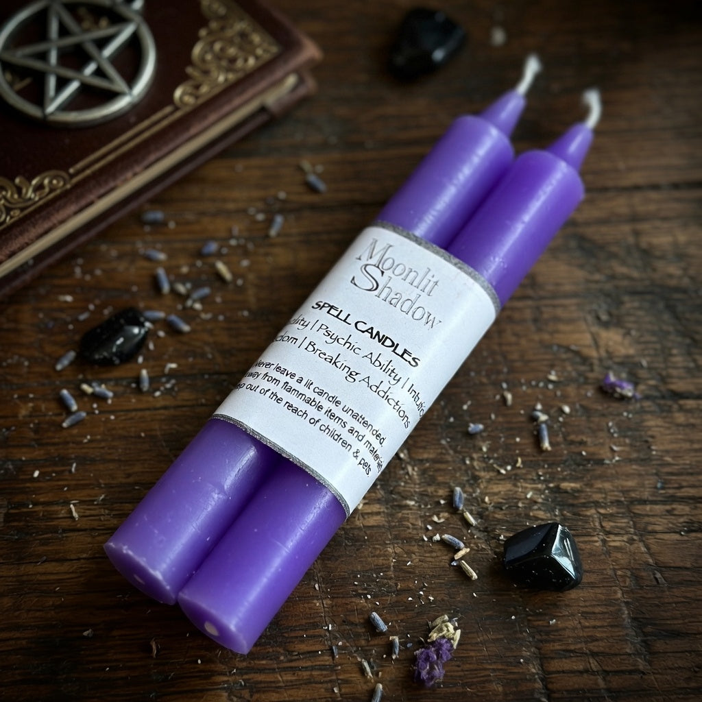 Purple spell candles with a label on a wooden surface with crystals and a pentacle symbol.