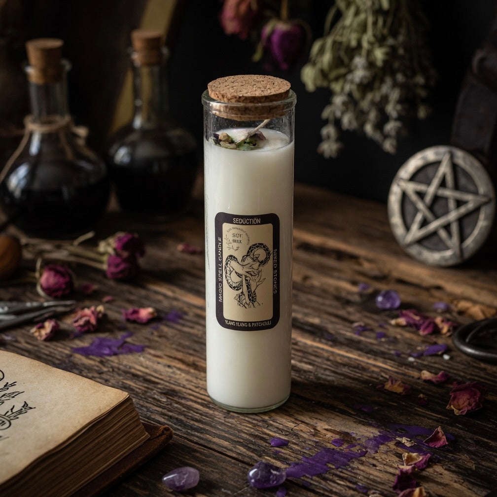 Magick spell candle for seduction in a glass jar with a cork lid on a wooden surface with flowers and a pentacle symbol.