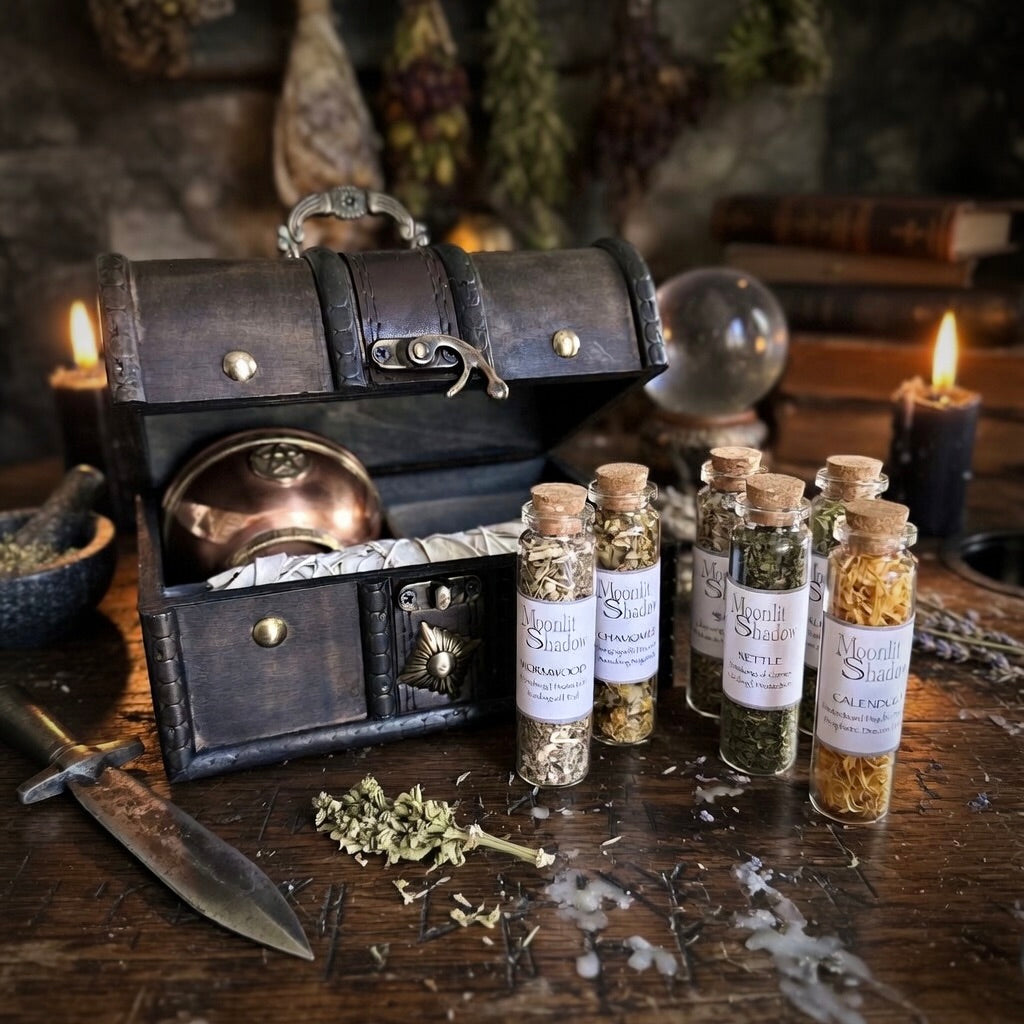 Smudging gift set with six glass bottles of herbs, including nettle, chamomile, wormwood and calendula, on a carved wooden surface with witchcraft related items