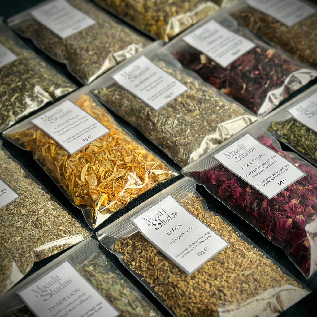 A selection of spell casting herbs in labelled sachets, close up. Mugwort, calendula, yarrow