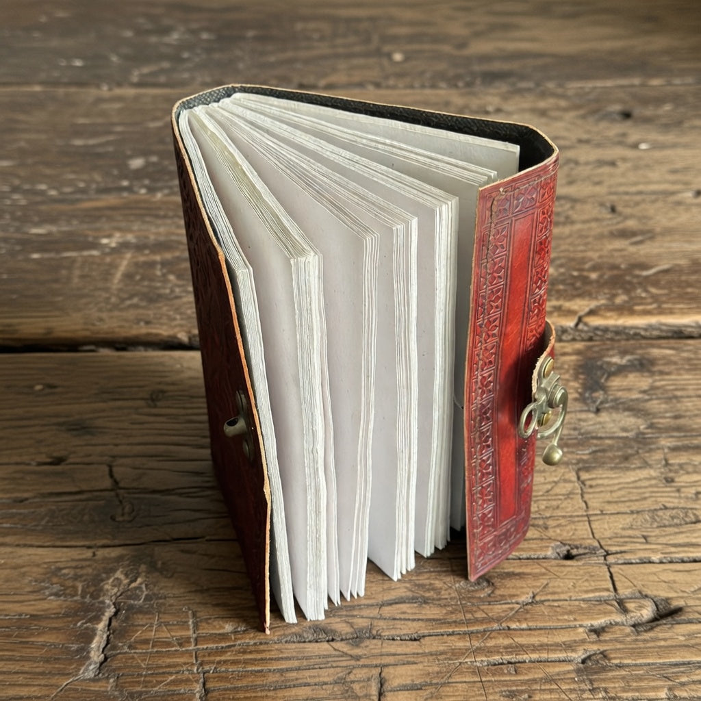 Open book with red leather cover on a wooden surface